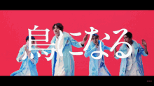 a group of men in blue coats are dancing in front of a red background with chinese characters