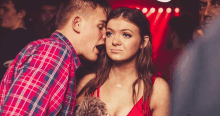 a man kisses a woman on the cheek in a crowded room