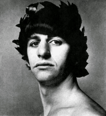 a black and white photo of a young man wearing a laurel wreath on his head .