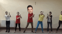 a group of people are dancing in front of a wall with a cross