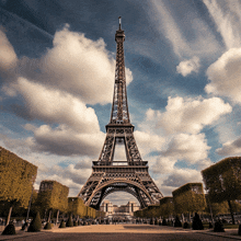 the eiffel tower is surrounded by trees and clouds