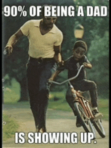 a man is teaching a young boy how to ride a bike