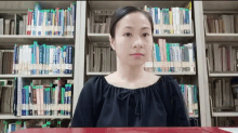 a woman stands in front of a bookshelf with a book titled ' a brief history of the world '