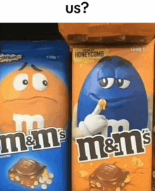 two boxes of m & m 's candy are sitting next to each other on a table .