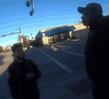 two men standing on a street in front of a building that has a sign on it that says no parking