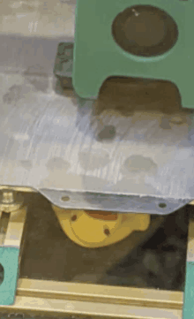 a yellow stuffed animal with a red nose is being pressed into a metal surface