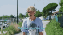 a young man wearing headphones and a blue t-shirt with the words `` we are who we are '' written on it .