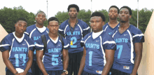 a group of young men wearing saints jerseys pose for a photo