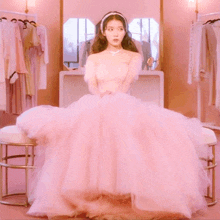 a woman in a pink dress is standing in a room