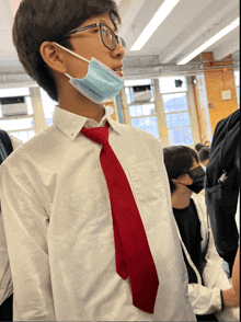 a boy wearing a red tie and a mask