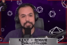 a man wearing headphones and a sign that says kent rogue on it