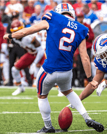 a football player with the number 2 on his jersey kicks the ball