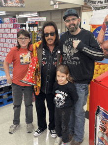 a man wearing a shirt that says mojo poses for a picture with two children