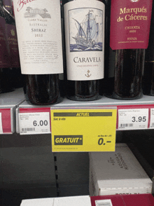 a bottle of caravela sits on a shelf next to a bottle of marques de caceres