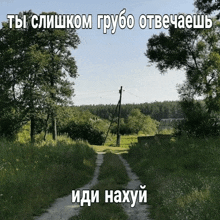 a dirt road going through a grassy field with russian writing