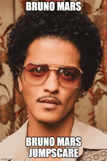 a man with curly hair wearing sunglasses and a mustache .