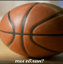 a basketball is sitting on a wooden table with a caption in russian