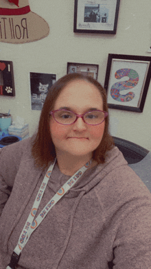 a woman wearing glasses and a lanyard that says cats on it