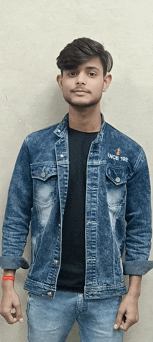 a young man wearing a denim jacket with since 1992 embroidered on the front