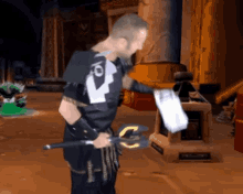 a man in a video game is holding a sword with a letter c on it