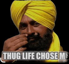 a man wearing a yellow turban smoking a cigarette with the words thug life chose me behind him