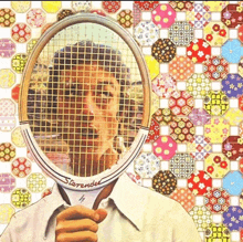 a man is holding a starinder tennis racquet in front of his face