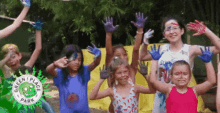 a group of children with their hands painted in different colors are standing in front of a banner that says green place park