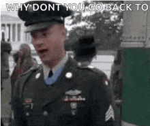 a man in a military uniform is standing in front of a white house and talking to another man .