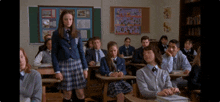 a girl in a school uniform stands in front of a group of students