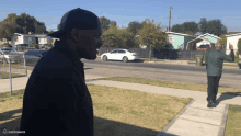 a man standing on a sidewalk with a playstation logo on the bottom