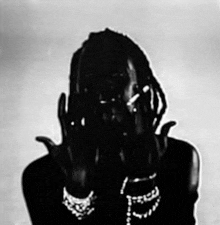 a black and white photo of a woman with dreadlocks covering her face .