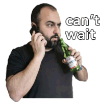 a man talking on a cell phone while holding a bottle of beer that says " can 't wait "