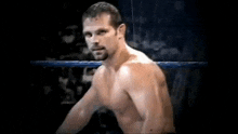 a shirtless man is standing in a wrestling ring .