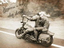 a man and woman are riding a motorcycle on a road .