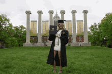 a woman in a graduation cap and gown holds a diploma in front of banners that say respect responsibility and excellence