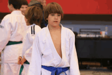 a boy in a white kimono with a blue belt