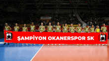 a group of volleyball players holding a banner that says ' sampiyon okanerspor sk '