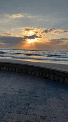 the sun shines through the clouds on the beach