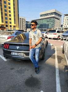 a man is standing in front of a mustang with a license plate that says d93460