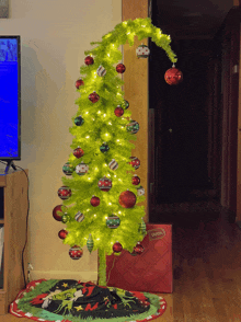 a green christmas tree with red and white ornaments