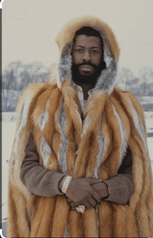 a man wearing a fur cape with a hood