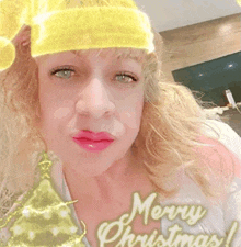 a woman wearing a yellow hat with the words merry christmas written on it .