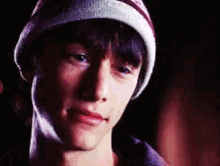 a close up of a young man wearing a beanie