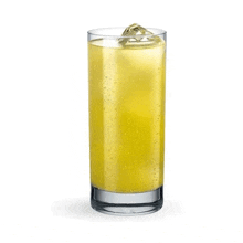 a tall glass filled with a yellow drink and ice .