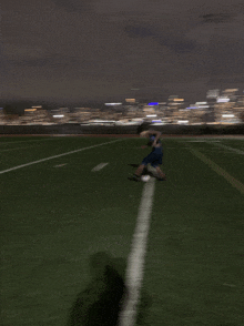 a blurry picture of a person playing soccer with a city in the background