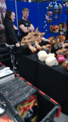 a man and a woman sit at a table with skulls and a sign that says ' skulls ' on it