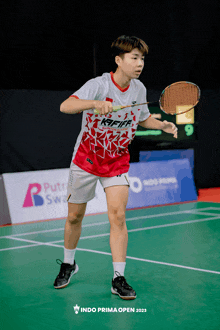 a person holding a badminton racket and wearing a jersey that says " indonesia open "