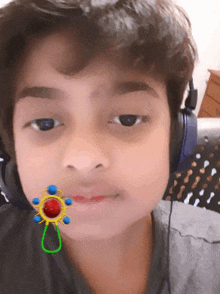 a young boy wearing headphones has a sticker on his face