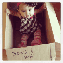 a baby is sitting in a cardboard box that says bows ava on it