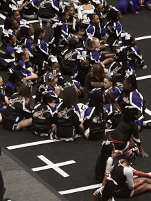 a group of cheerleaders are sitting on the floor with one wearing a black jacket that says chasers